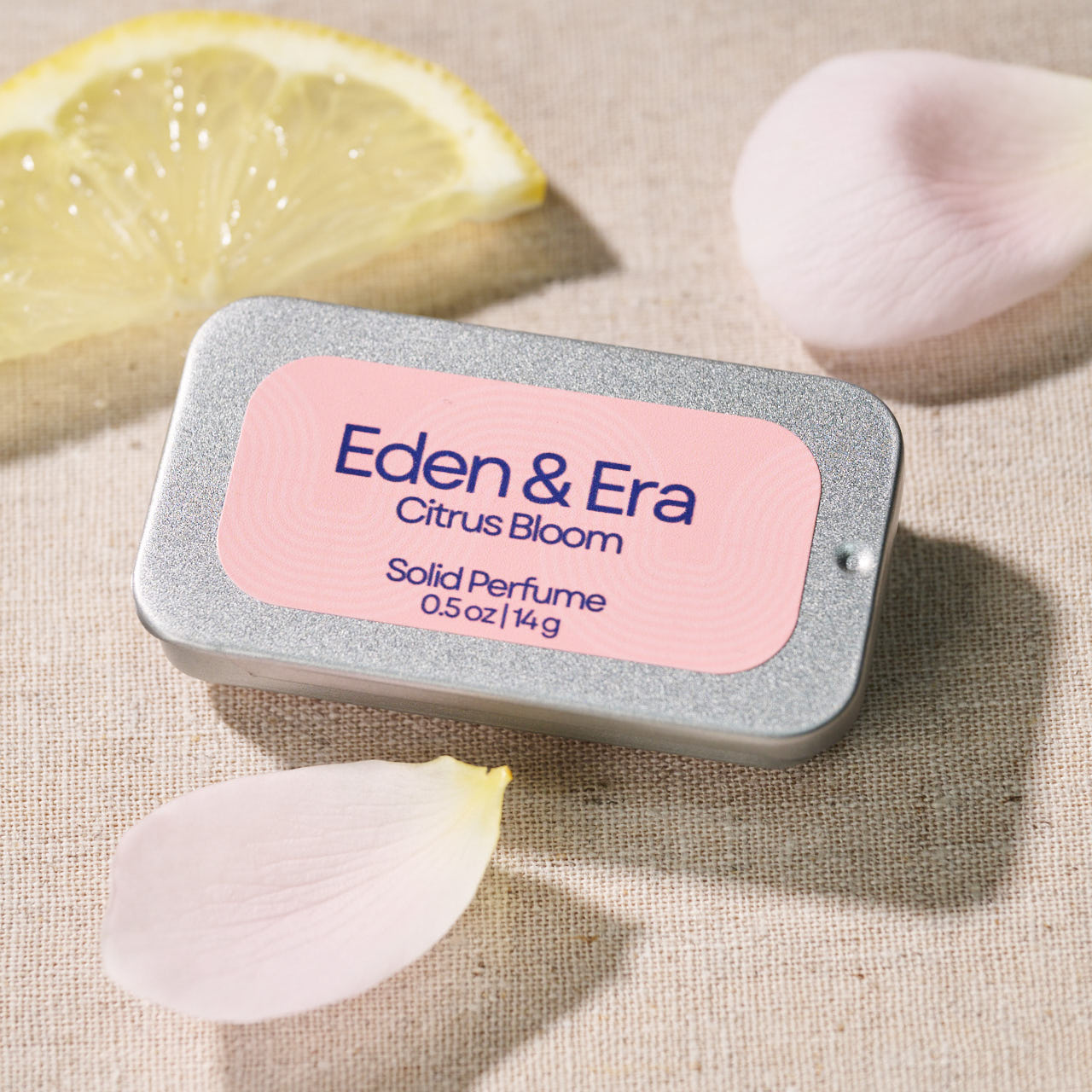 Eden & Era Citrus Bloom solid perfume tin with lemon and petals