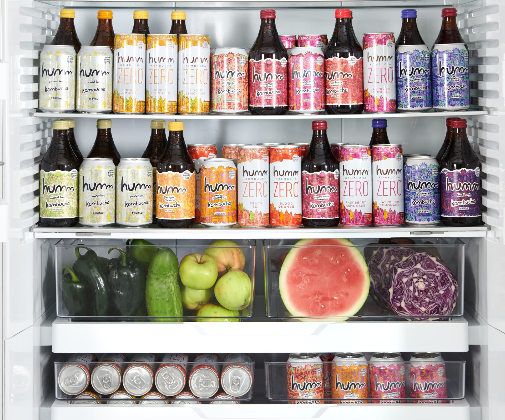 Refrigerator styled with a full range of Humm Kombucha bottles, cans, and fresh produce