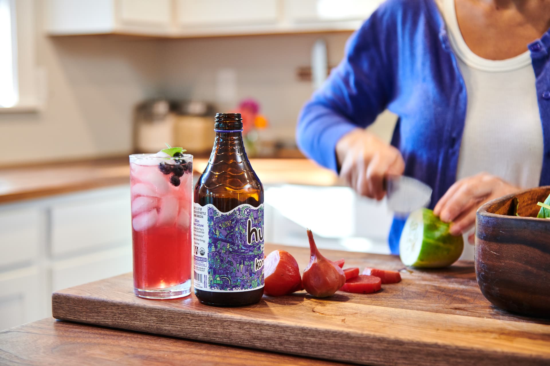 Humm blackberry kombucha styled on a kitchen cutting board