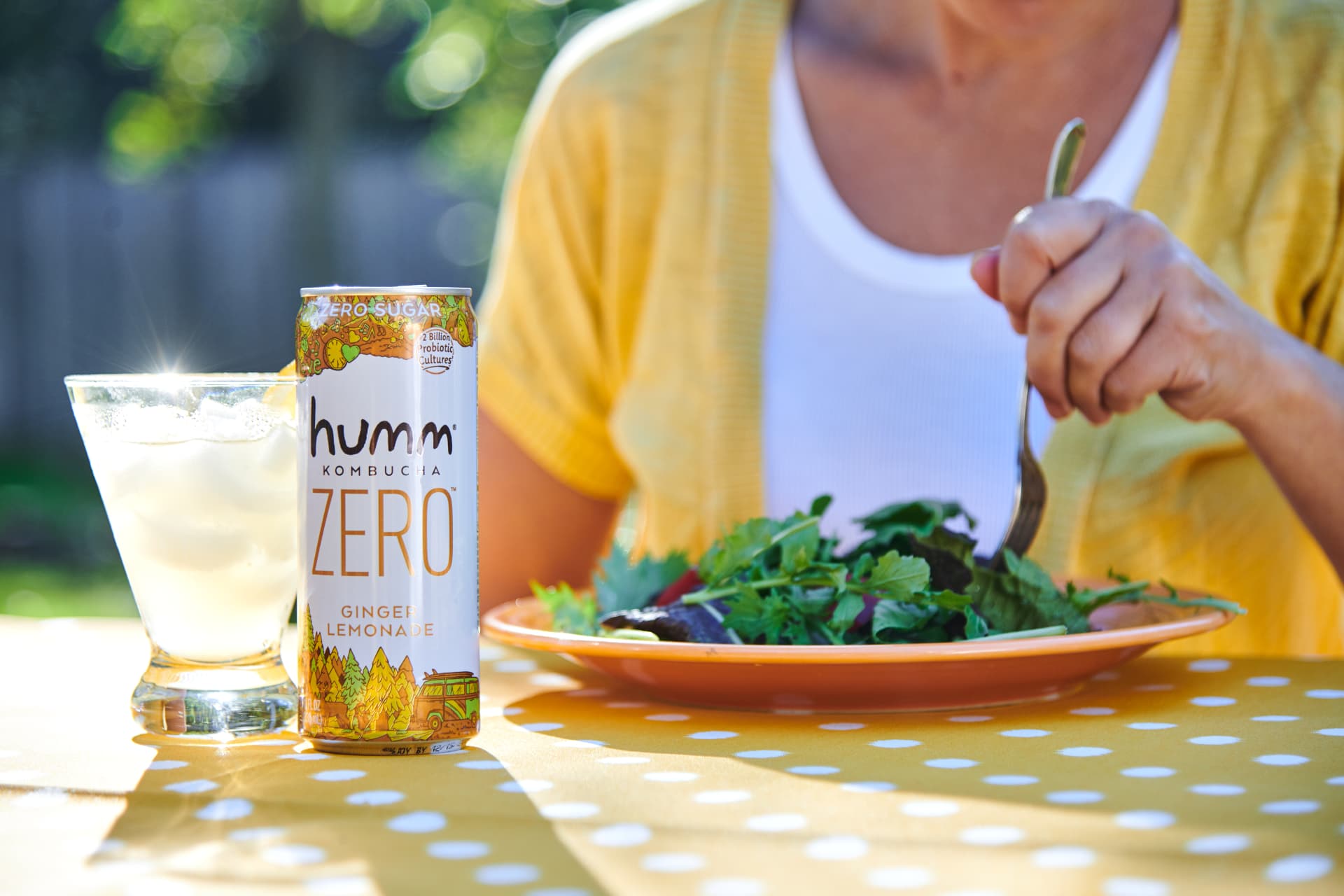 Humm Zero Ginger Lemonade can on a sunlit outdoor table with a salad